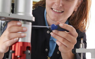 Kvinne som reparerer graveringsmaskin