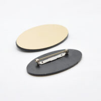 520100252 Ovalt jakkeskilt i radiant gull-sort