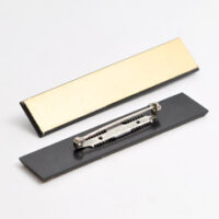 520102570 Jakkeskilt i glossy gull-sort